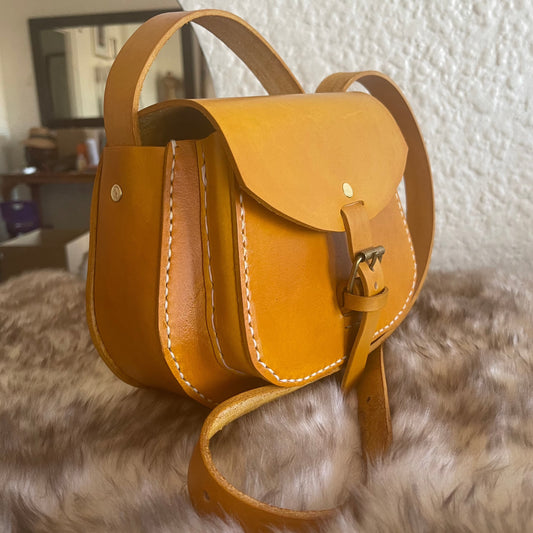 genuine leather saddle stitched yellow bag on top of sheepskin