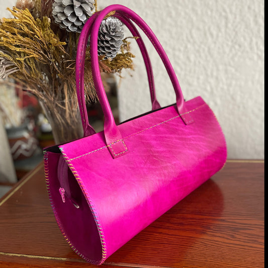Pink genuine leather handbag on a table