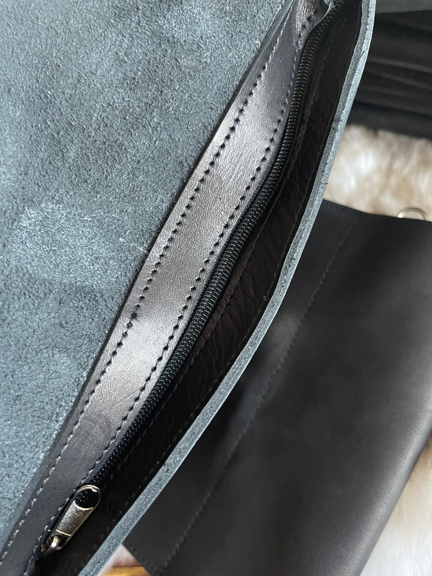 zip part of a genuine leather black sling bag