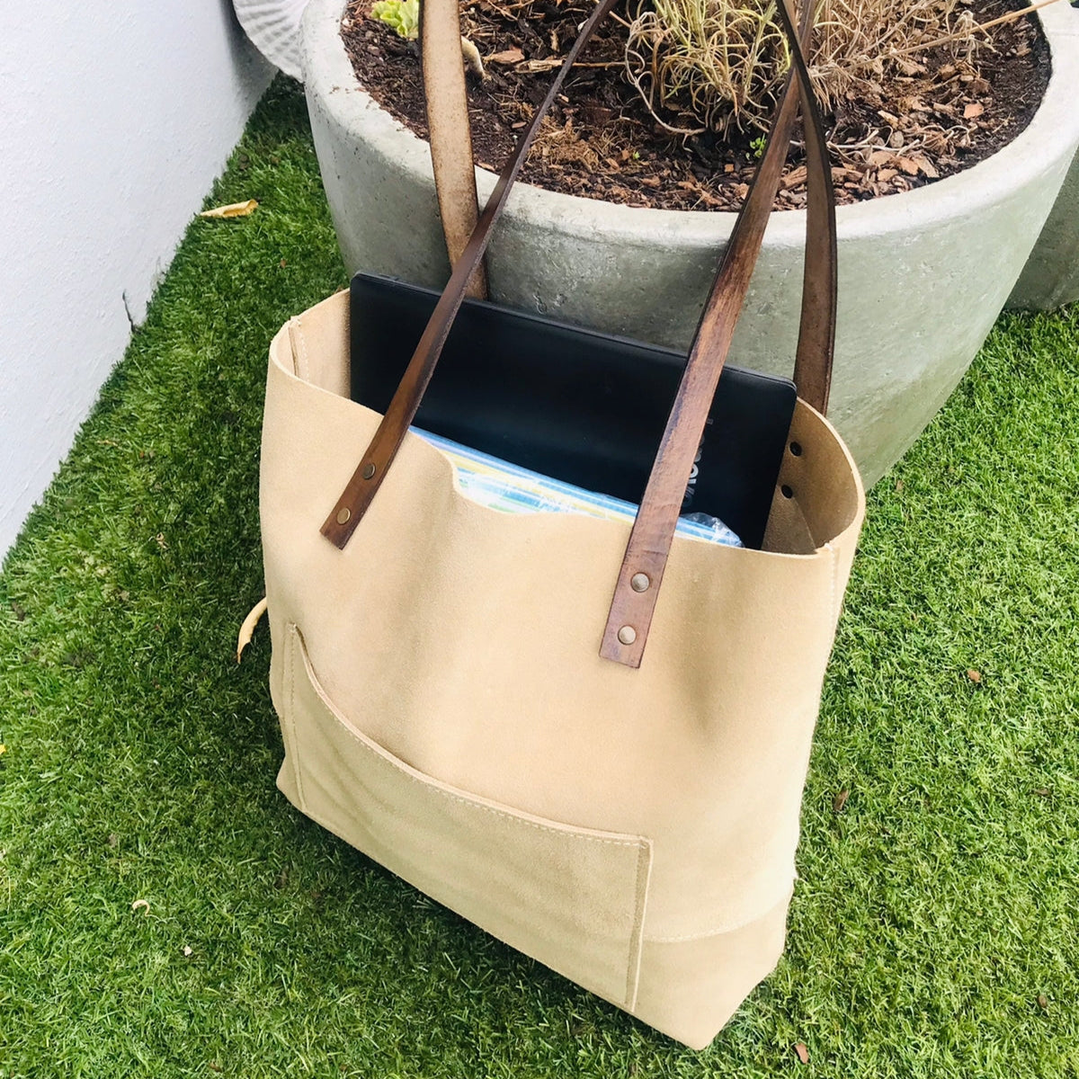 Green genuine leather tote bag with sturdy handles and minimalist design