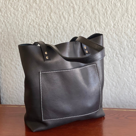 Black genuine leather shopper on a wooden table by NaniTa and Co  