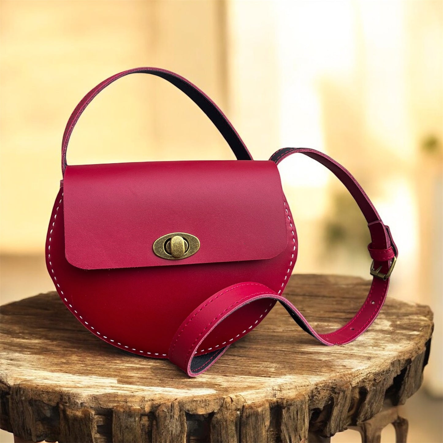 Pink handbag with a gold clasp on a wooden surface