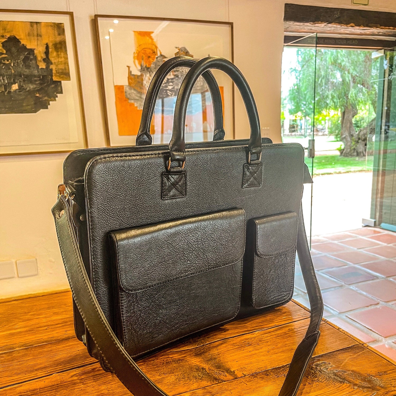 Black genuine leather black laptop bag by NaniTa and Co on a table