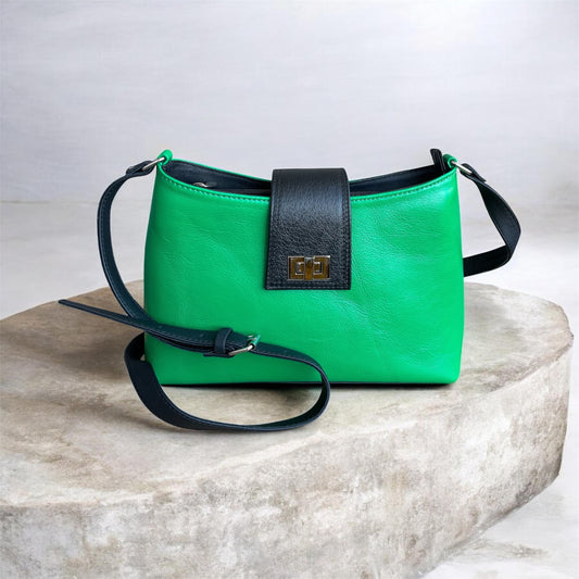 Green handbag with black accents on a marble surface