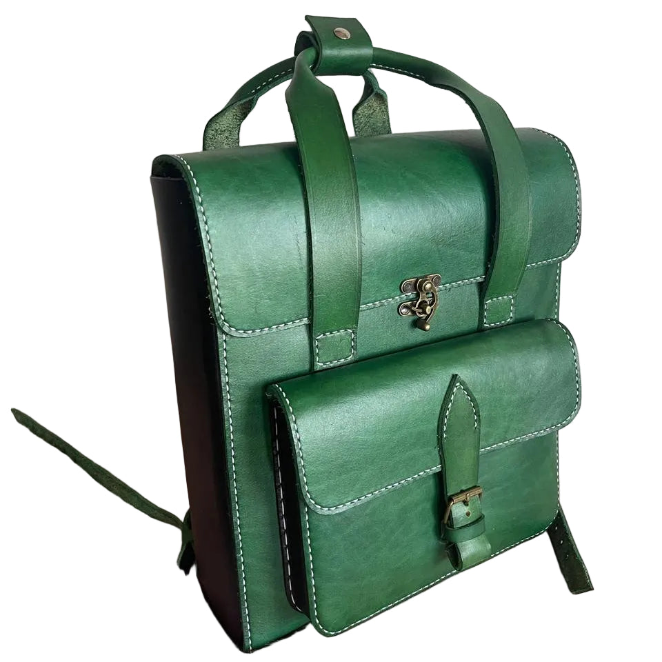 Green leather satchel bag on a pink surface with a white wall background