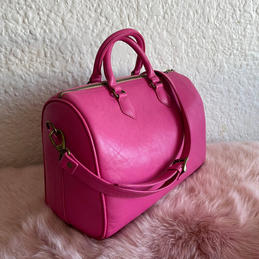 Genuine leather pink mini duffel cross body on a pink sheepskin
