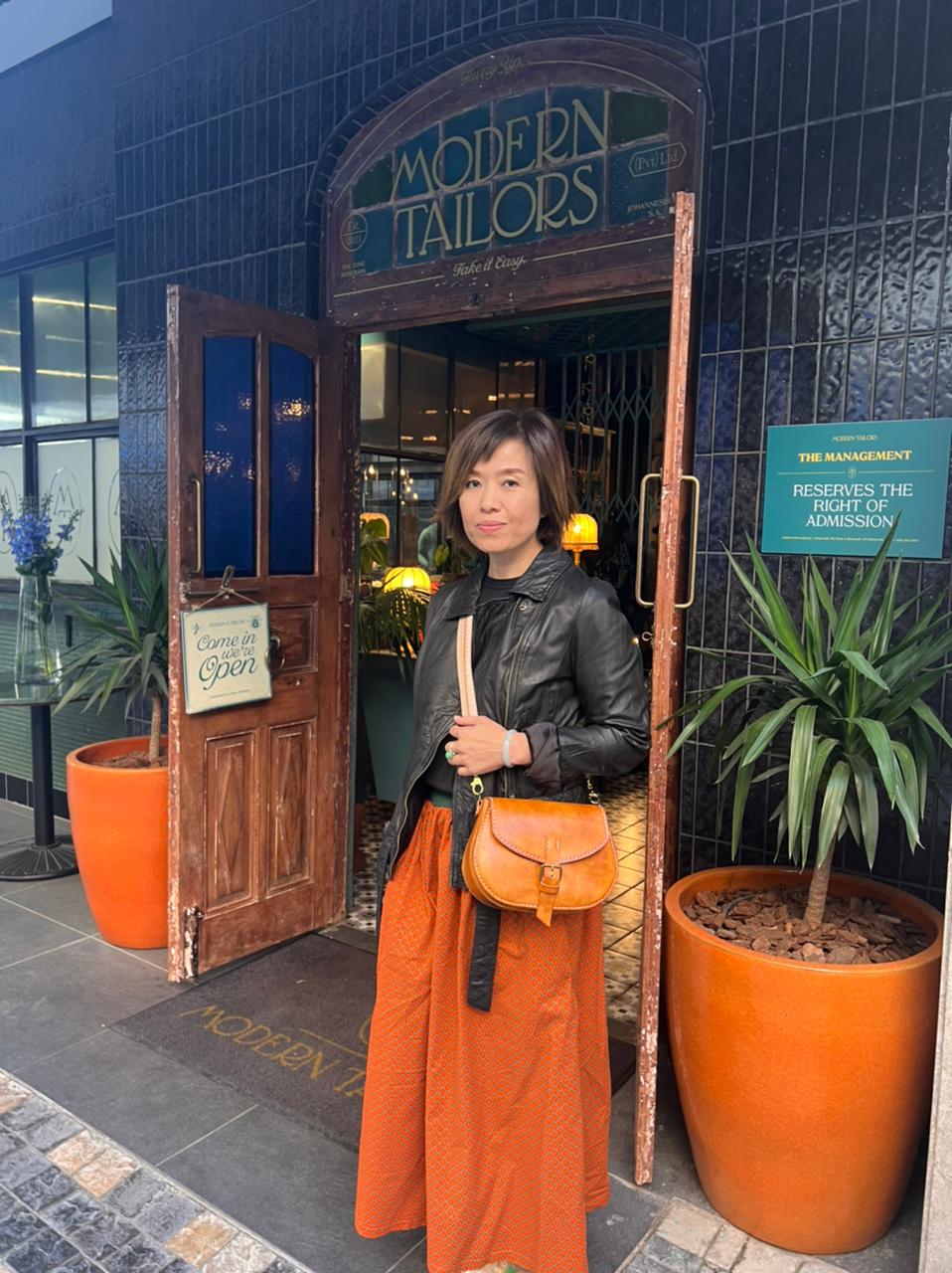 a woman standing with a genuine leather bag