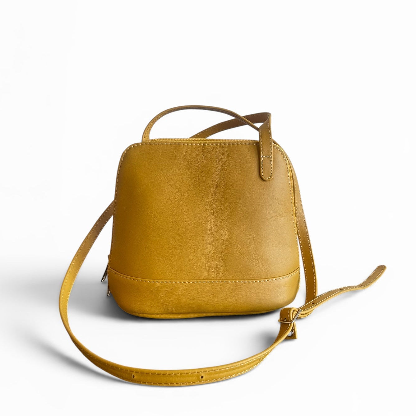 Yellow leather handbag with a strap on a white background