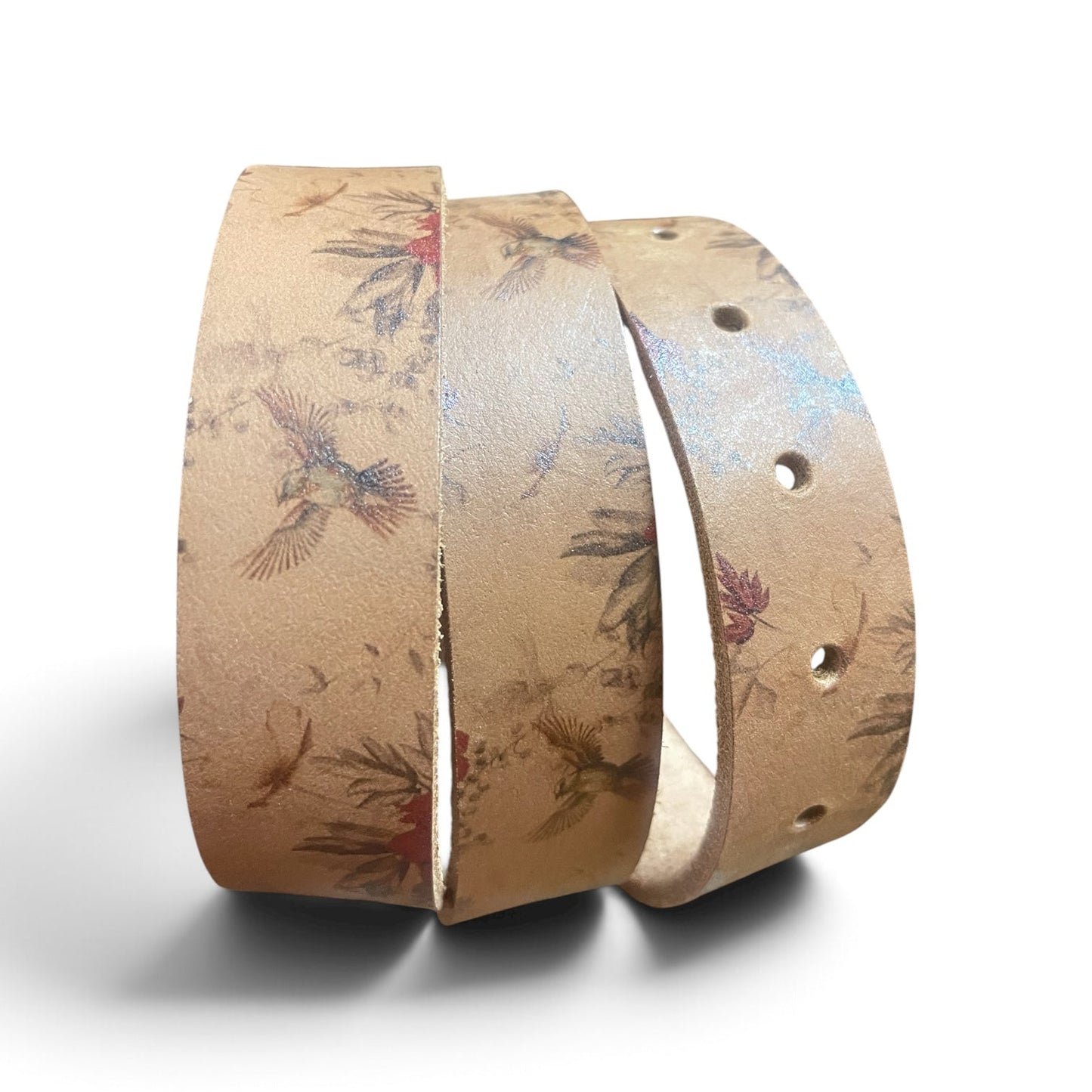 A tan leather belt with a detailed bird and floral pattern, shown coiled on a white background.