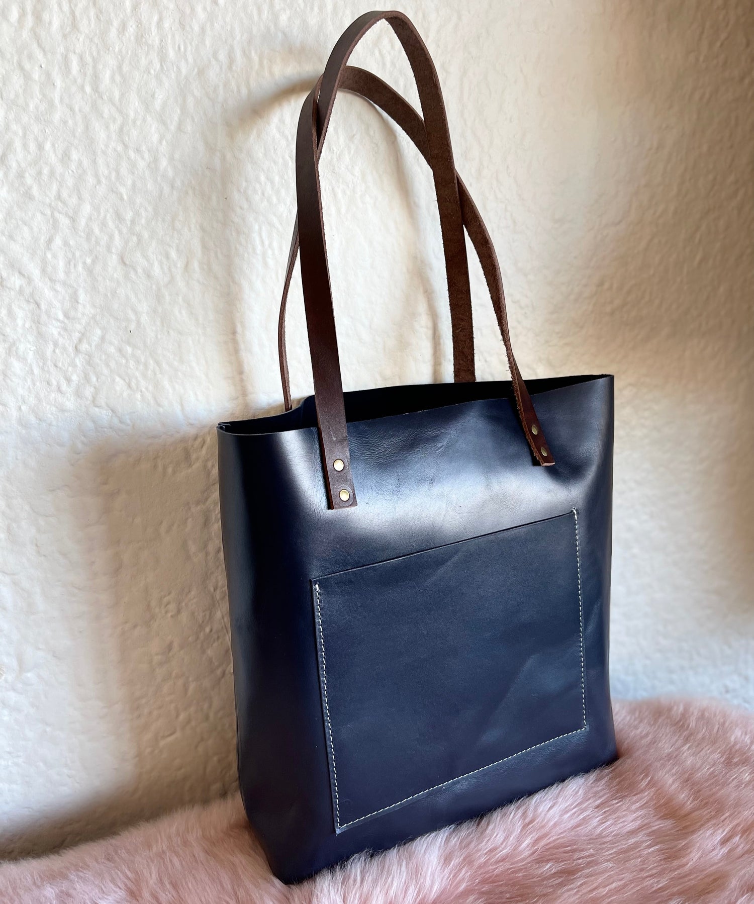 Navy genuine leather tote bag with sturdy handles and minimalist design