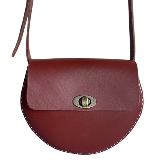 Brown leather handbag with a gold clasp on a white background