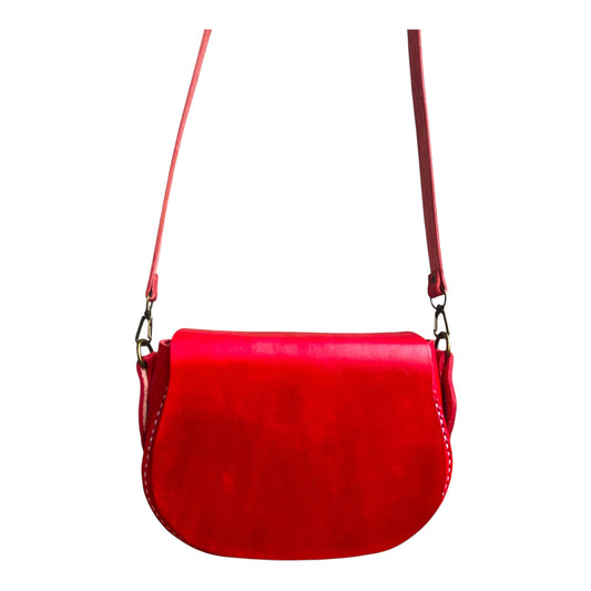 Red genuine leather handbag with a strap on a white background