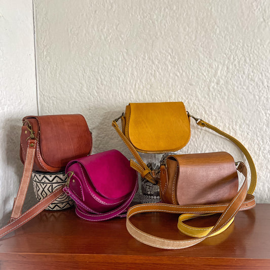 4 genuine leather handbags on a wooden table