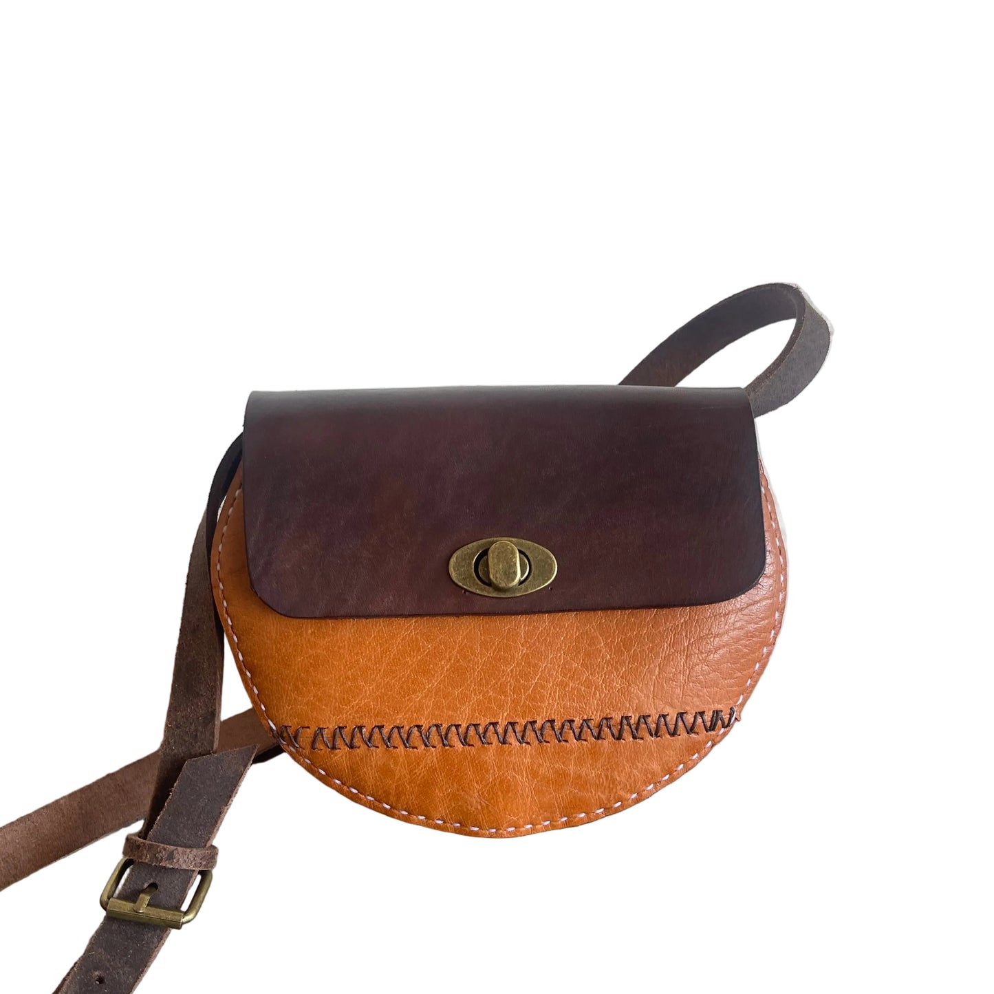 Brown leather crossbody bag with a strap on a white background