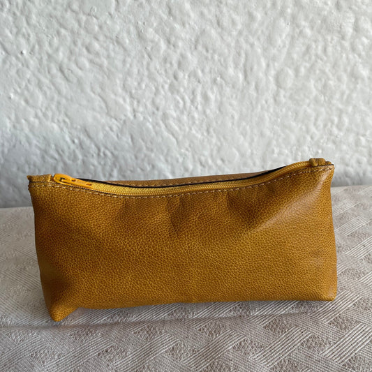 Brown leather pouch on a textured white surface