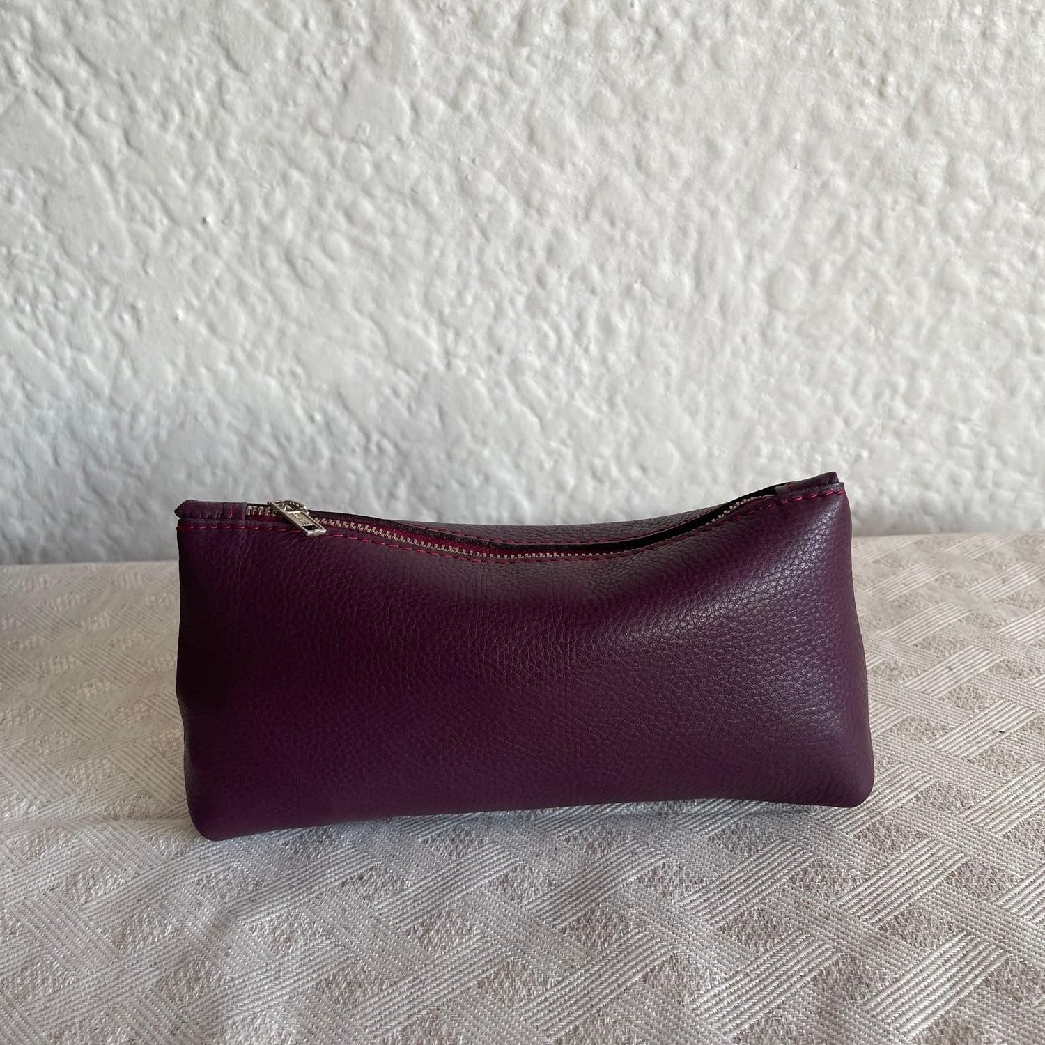 Purple leather case on a textured white surface