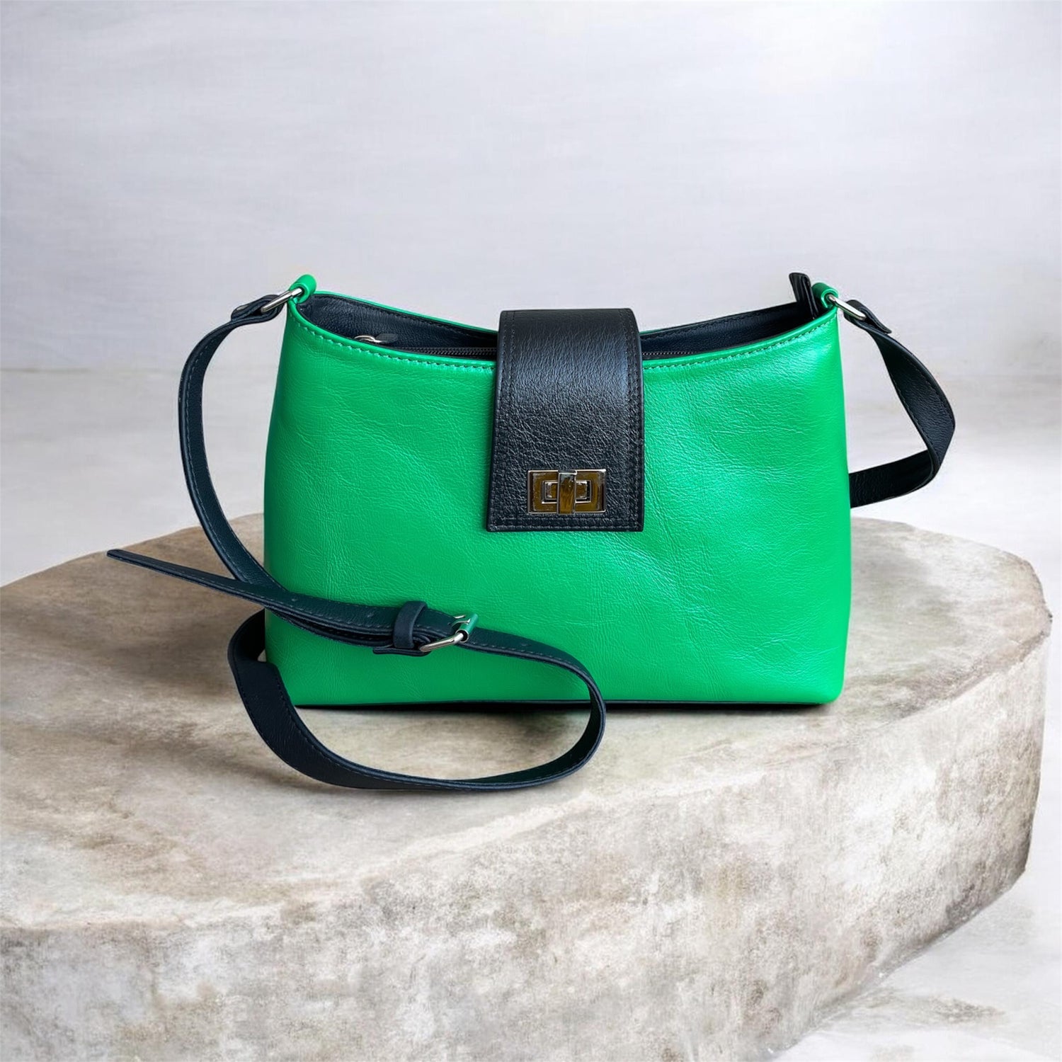 Green handbag with black accents on a marble surface