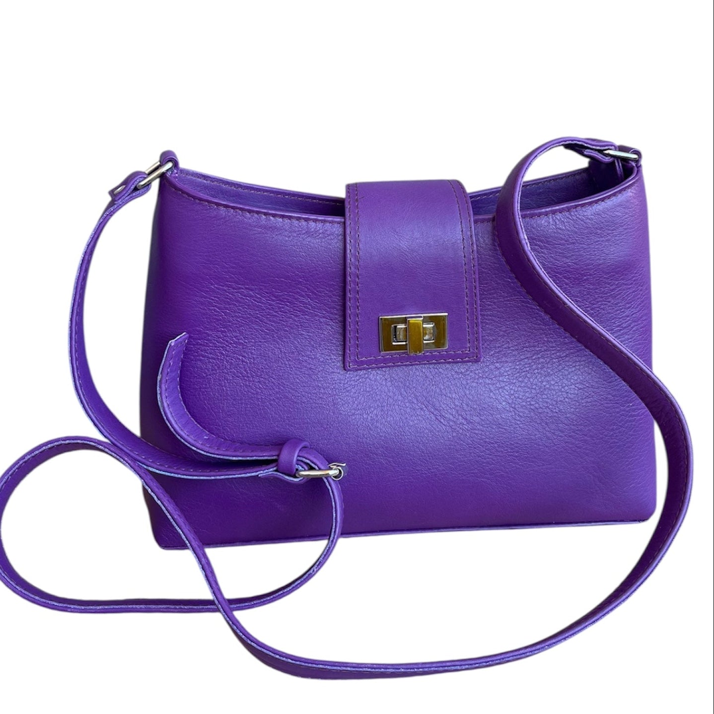 Purple genuine leather handbag with a strap on a white background