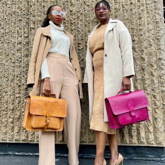 2 ladies holding NaniTa hand-stitched 13 inch leather laptop bags