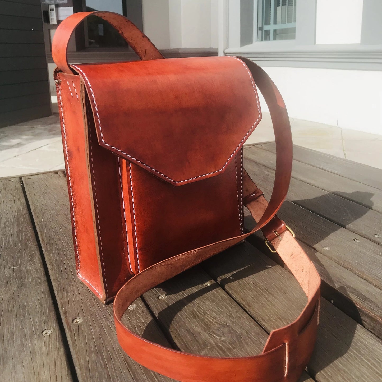 oak hand-stitched genuine leather man bag on a table